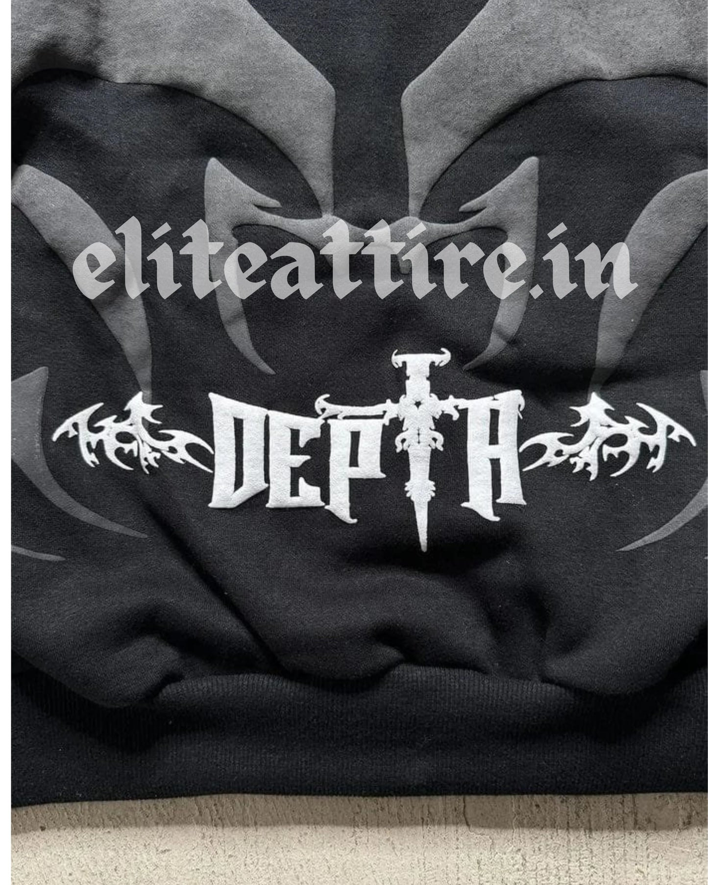 Black hoodie with white text and design on a textured surface