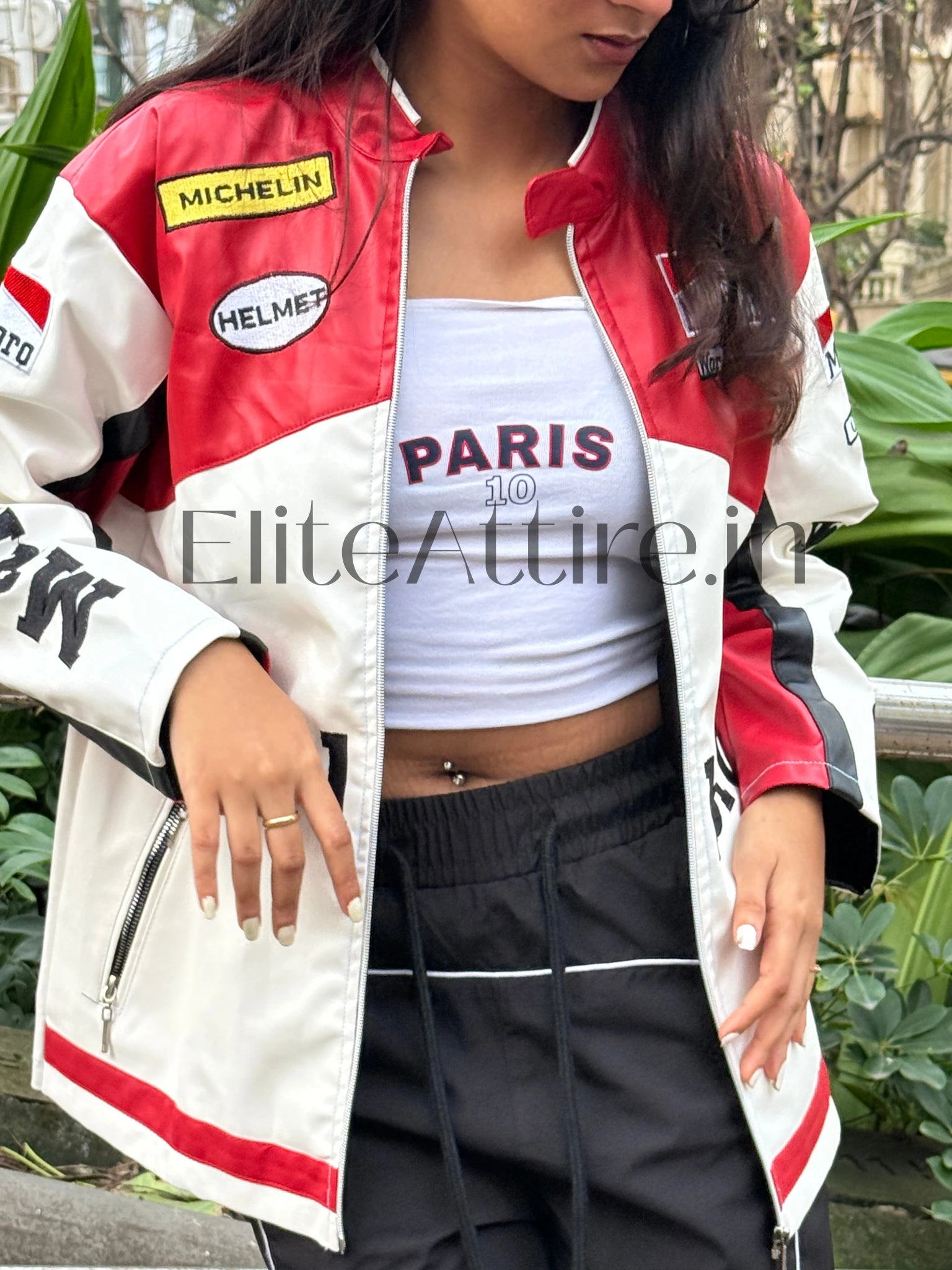 Person wearing a red, white, and black jacket with visible branding, standing outdoors.