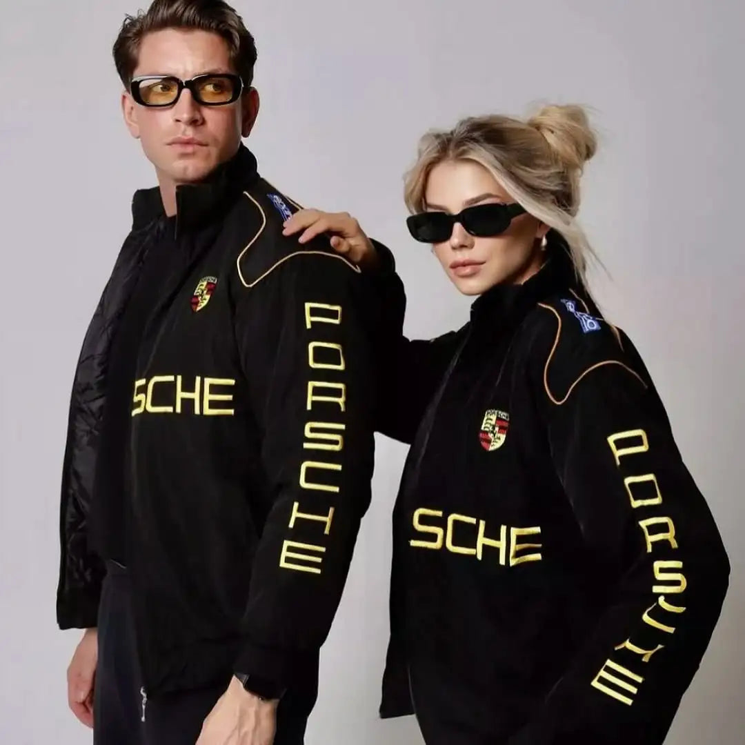 Two people wearing matching black jackets with 'Porsche' branding on a gray background