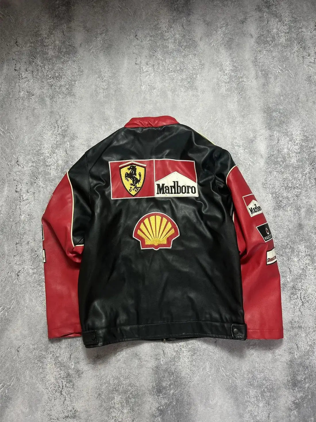 Black and red leather jacket with various logos on a gray background