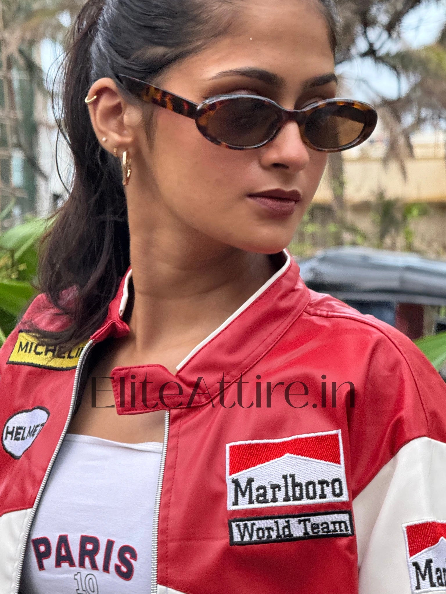 Person wearing a red and white jacket with visible branding, outdoors.