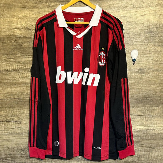 Red and black striped sports jersey with Adidas and Bwin logos on a wooden background