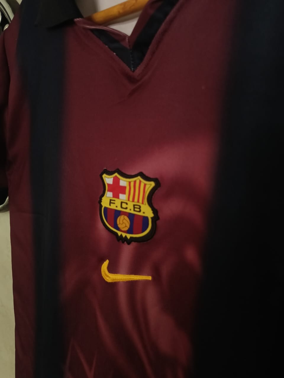 Maroon sports jersey with FC Barcelona logo and Nike swoosh on a dark background