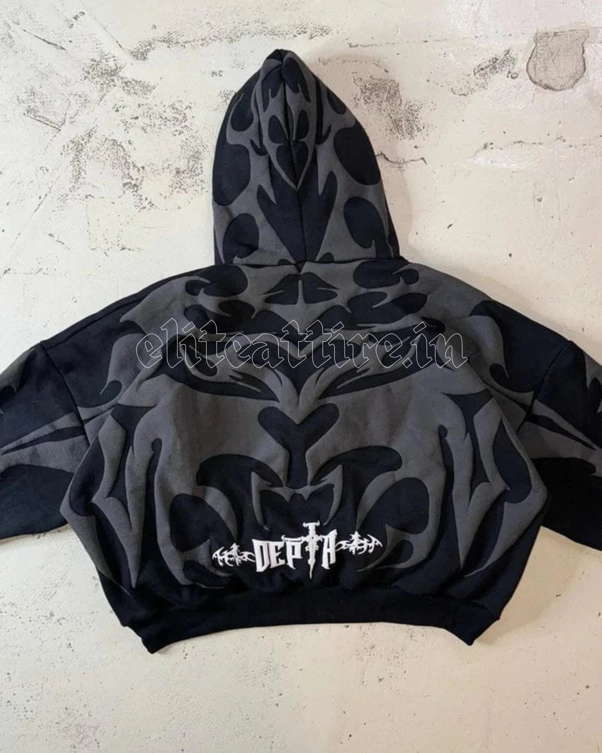 Black hoodie with white logo on a textured surface