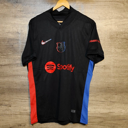 Black sports jersey with multiple logos on a wooden surface