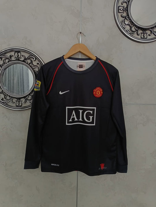 Black sports jersey with visible branding on a hanger against a tiled wall.