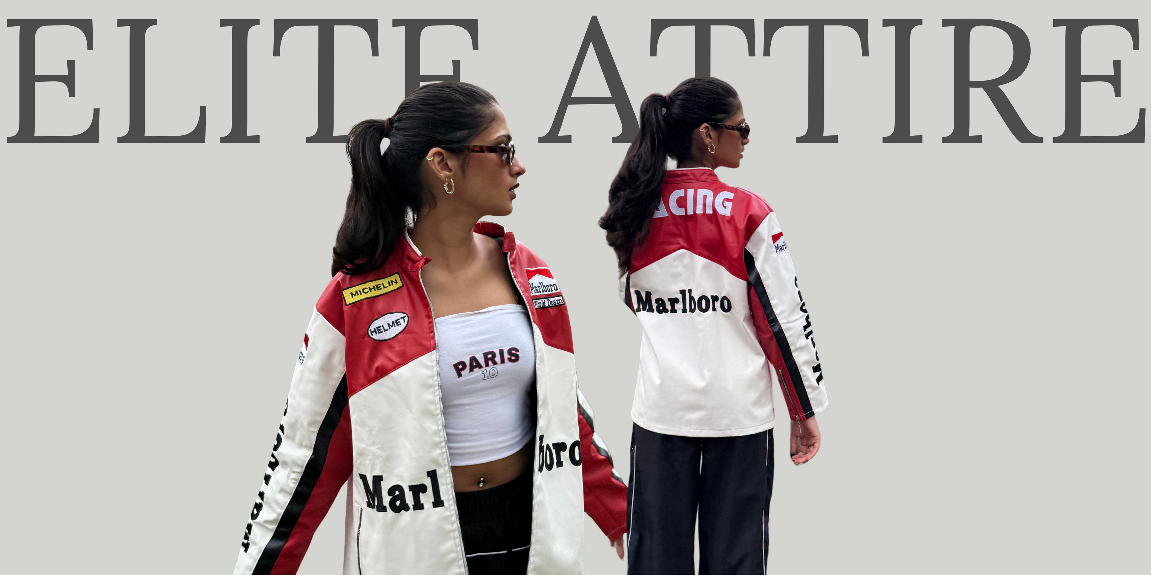 Two women wearing matching racing-themed outfits with visible branding in front of a 'Elite Attire' sign.