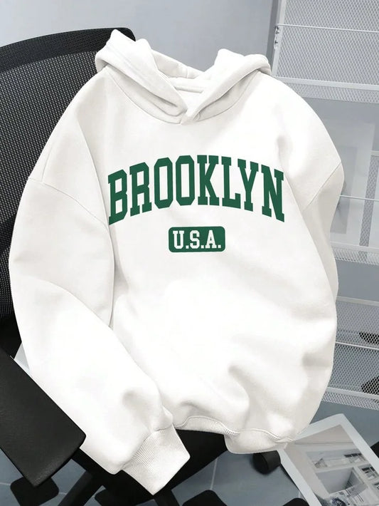 White hoodie with 'Brooklyn U.S.A.' text on a chair.