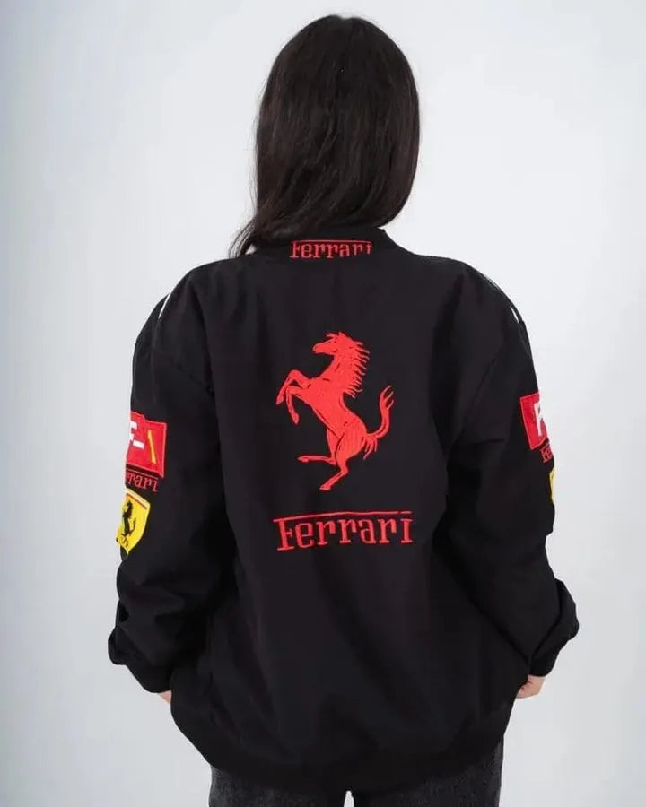 Person wearing a black Ferrari jacket with red logo on a white background