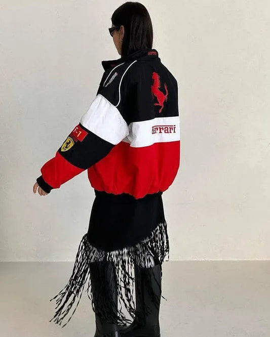 Person wearing a black, red, and white jacket with Ferrari logos on a plain background