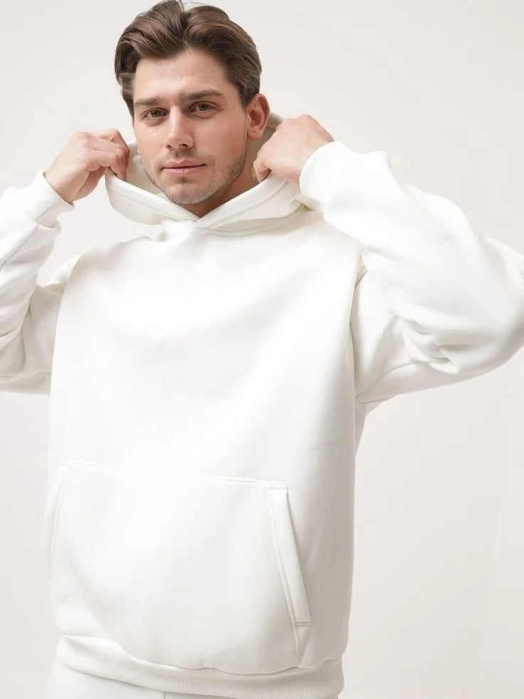 Man wearing a white hoodie against a plain background
