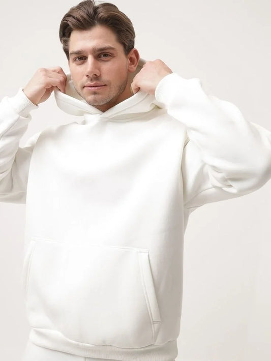 Man wearing a white hoodie against a plain background